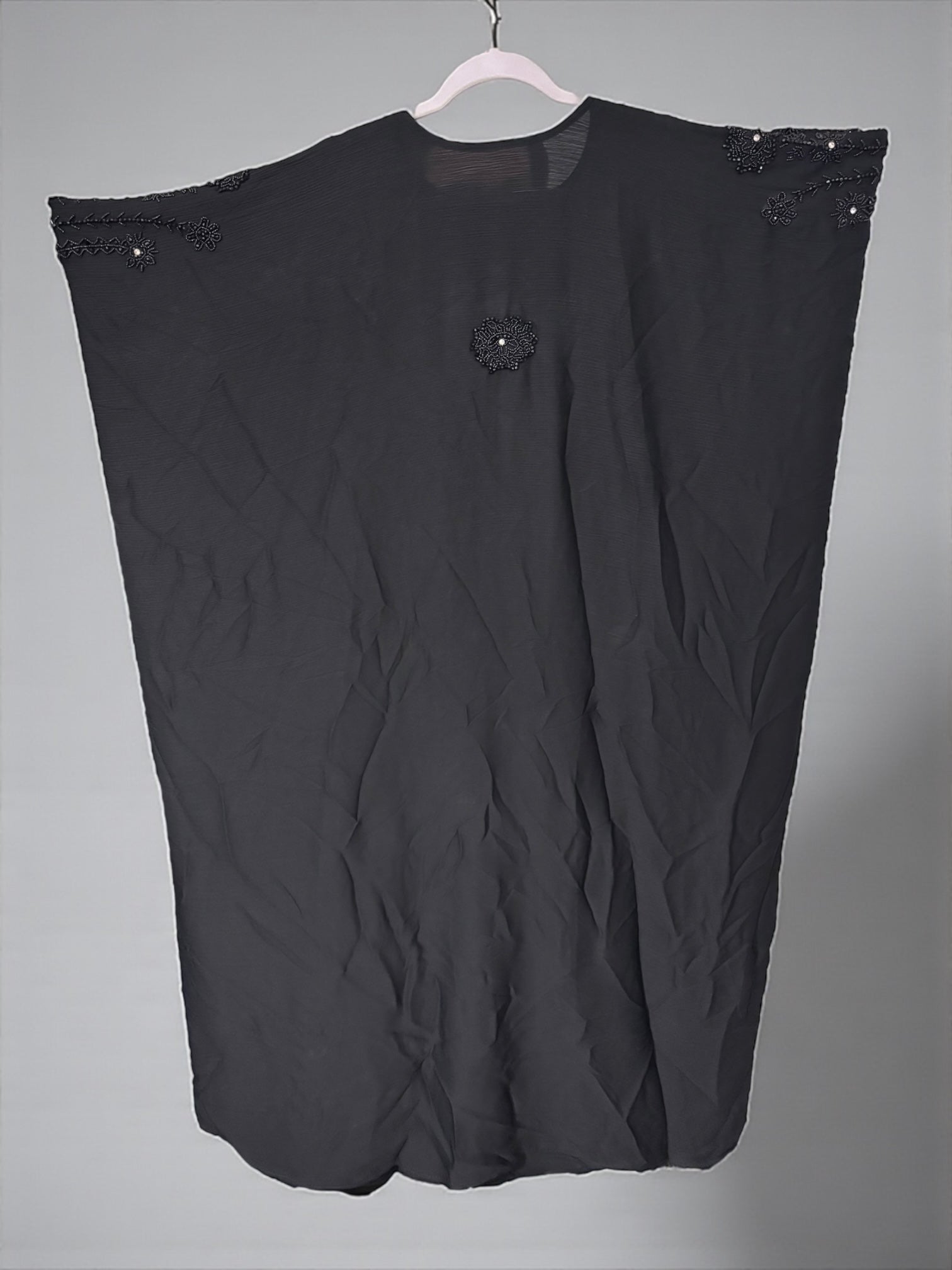 Women’s black kaftan abaya by Saree Ghor Charlotte, modest Islamic dress with flowing fabric and intricate embroidery.