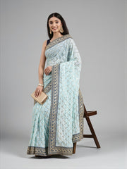 Elegant beige georgette saree by Saree Ghor Charlotte, traditional cultural wear for women with intricate drape details.