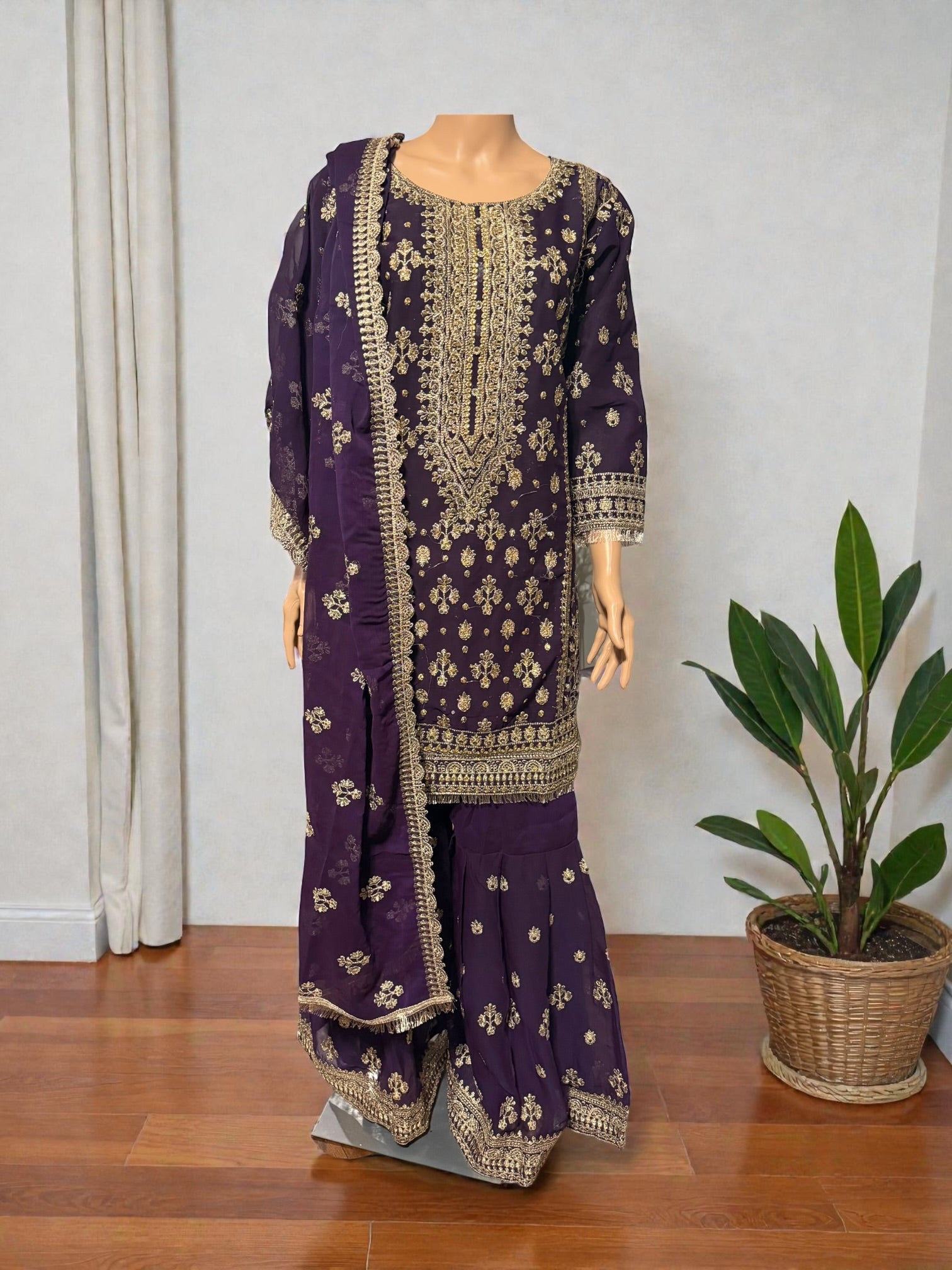 Traditional Salwar Kameez for women by Saree Ghor Charlotte, featuring intricate embroidery and vibrant fabric in a cultural design.