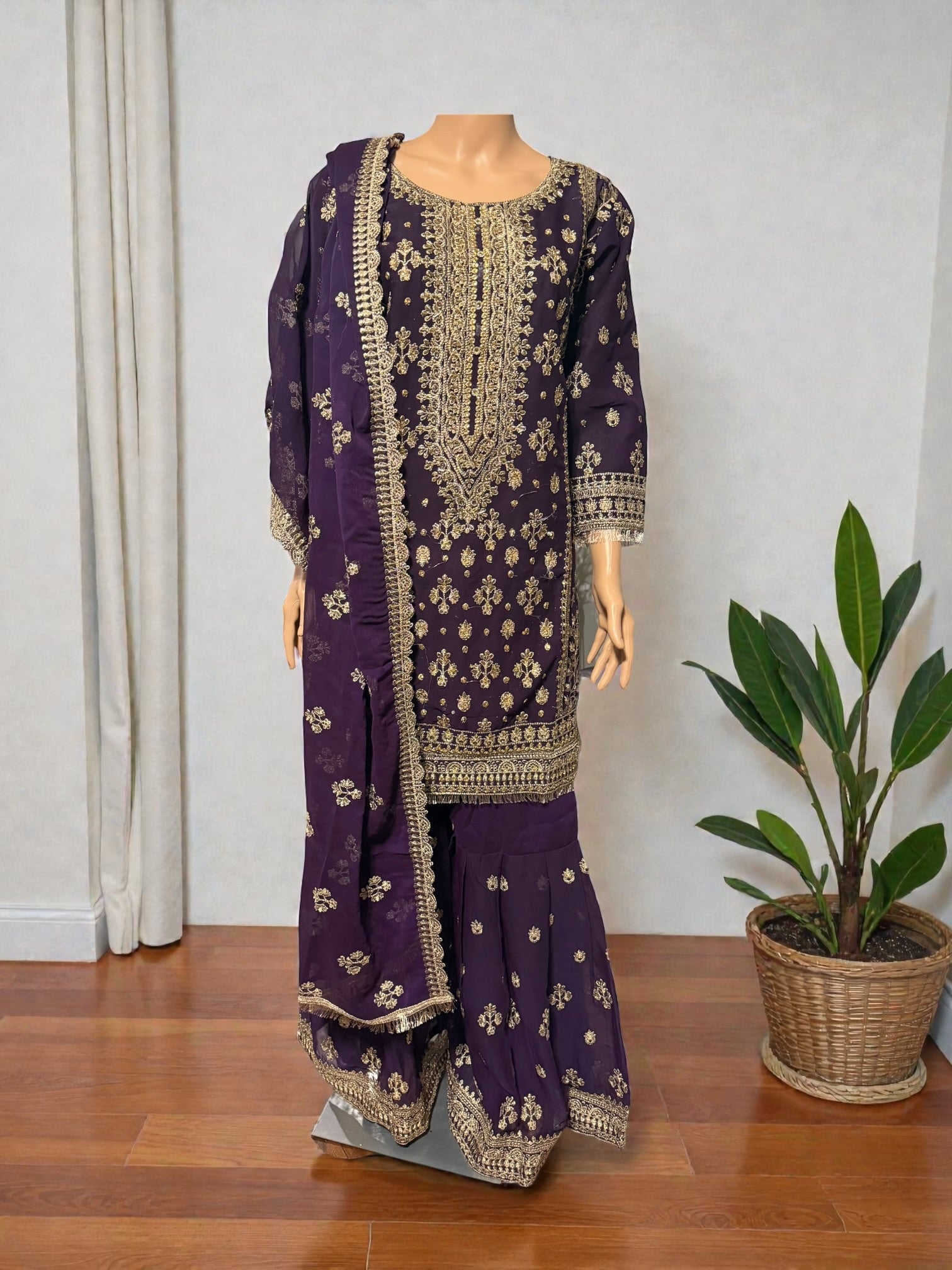 Traditional Salwar Kameez for women by Saree Ghor Charlotte, featuring intricate embroidery and vibrant fabric in a cultural design.