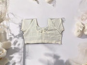 Cream-colored traditional ready-made blouse for saree by Saree Ghor Charlotte, featuring ethnic design and elegant fit for women.