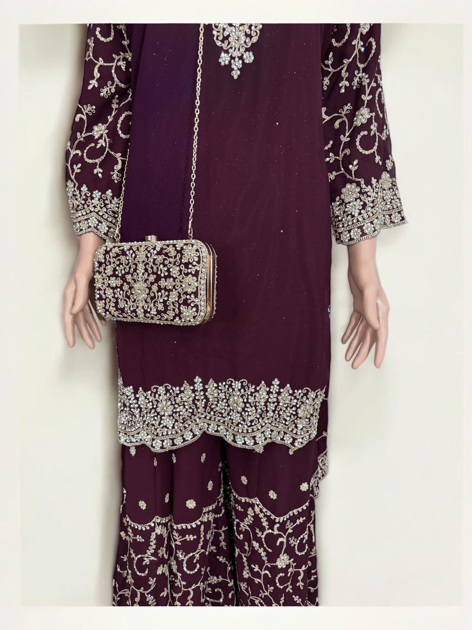 Purple traditional designer Salwar Kameez suit with matching handbag, worn by a woman showcasing ethnic attire.