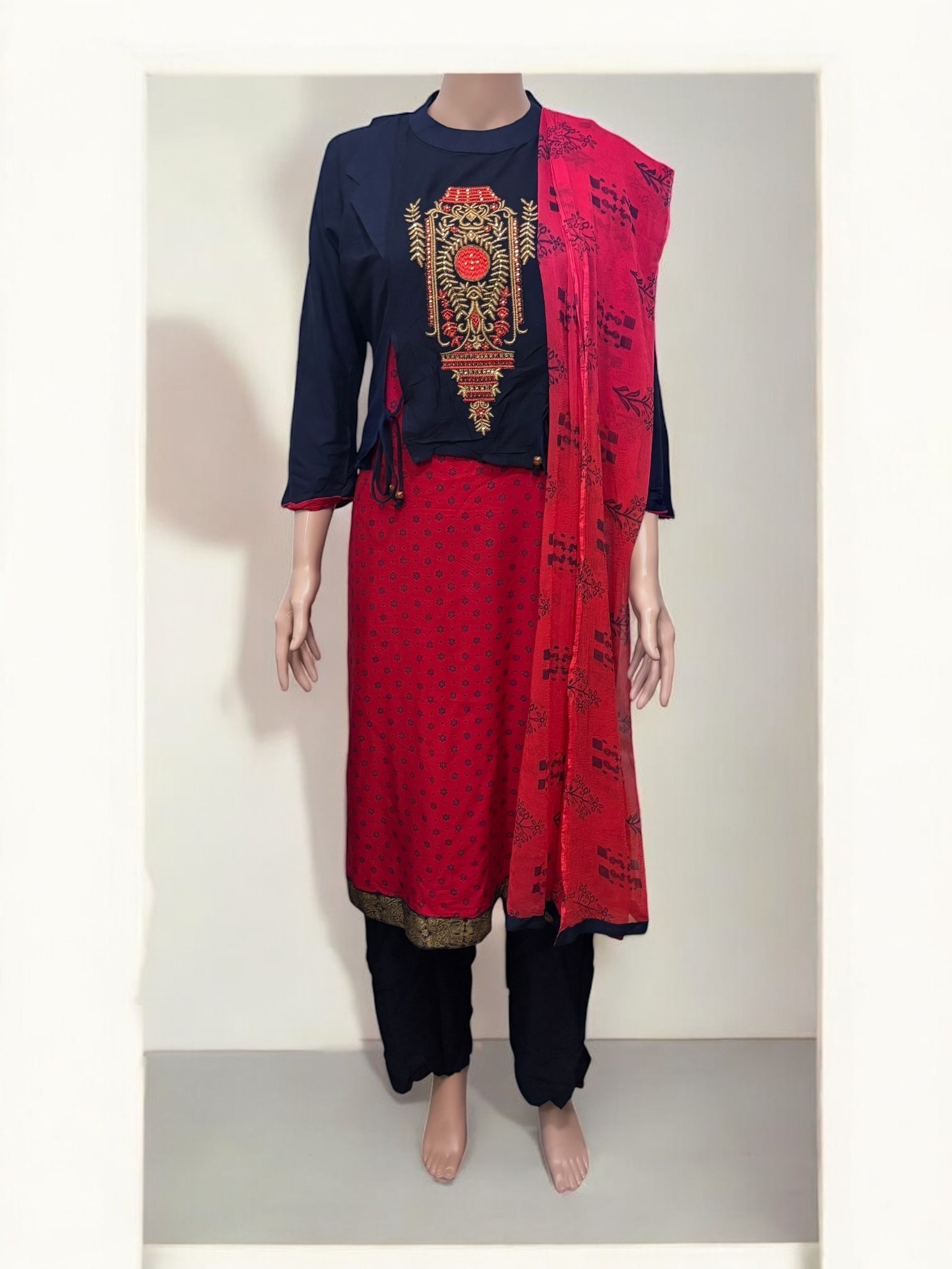 Traditional Salwar Kameez set by Saree Ghor Charlotte, ethnic women’s wear with intricate embroidery and vibrant fabric details.